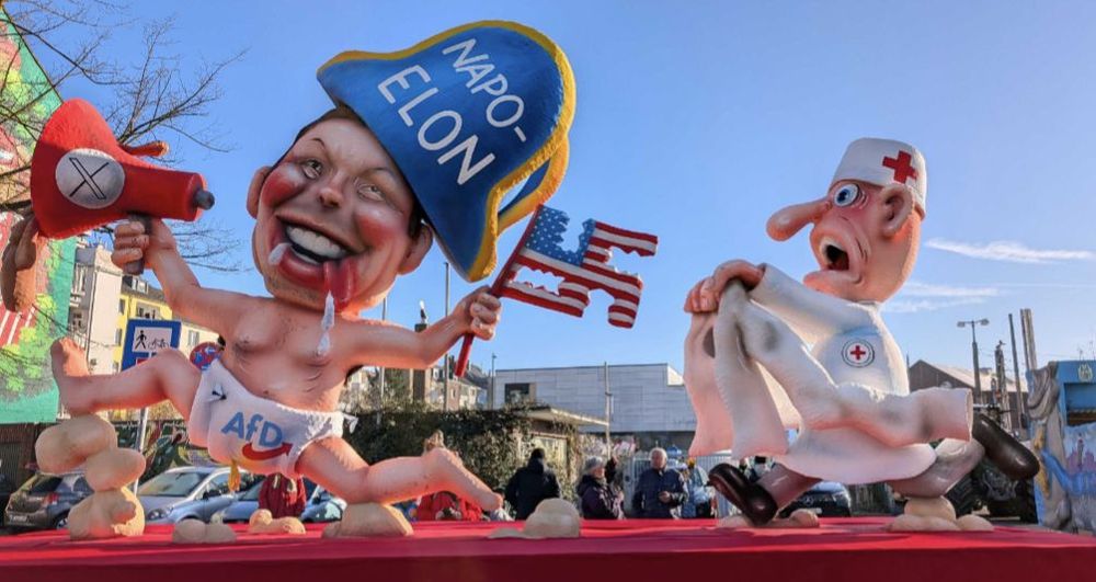 carnival wagon motive from Düsseldorf, Germany. You see Elon Musk drooling in Diapers with a red megaphone on which the X from former Twitter platform can be seen so the whole thing is black-white-red, just like the flags from Nazi Germany.
He wears a Napoleon like hat saying "Napo - Elon", is holding a flag with stars ans stripes, which hat parts cut out so it looks like a swastika in US colors.
Some medical person is trying to catch him as he obiously lost his mind.