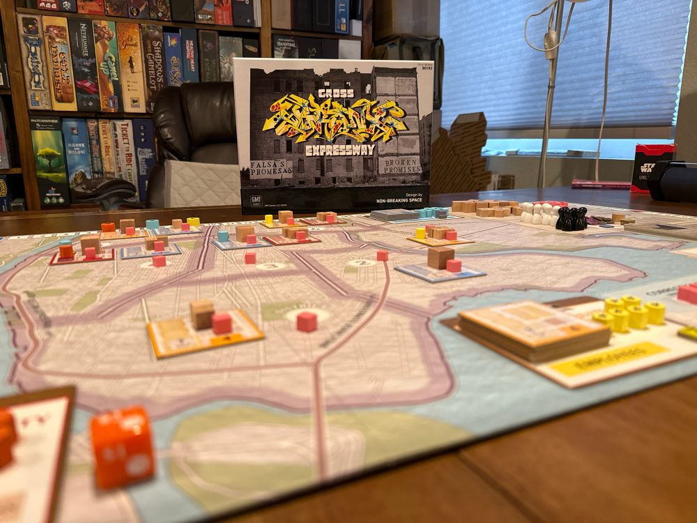 The board game Cross Bronx Expressway, set up with the game box behind the board. 