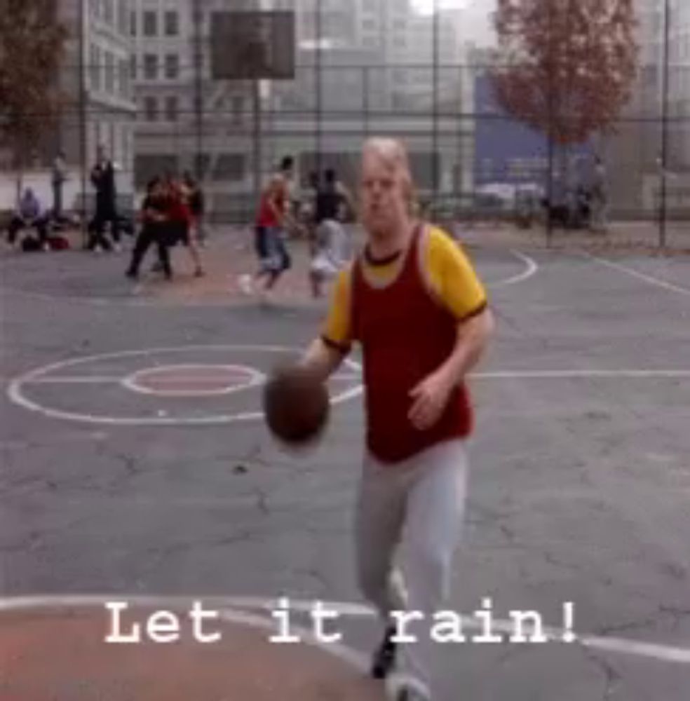 a man is holding a basketball on a basketball court with the words let it rain below him