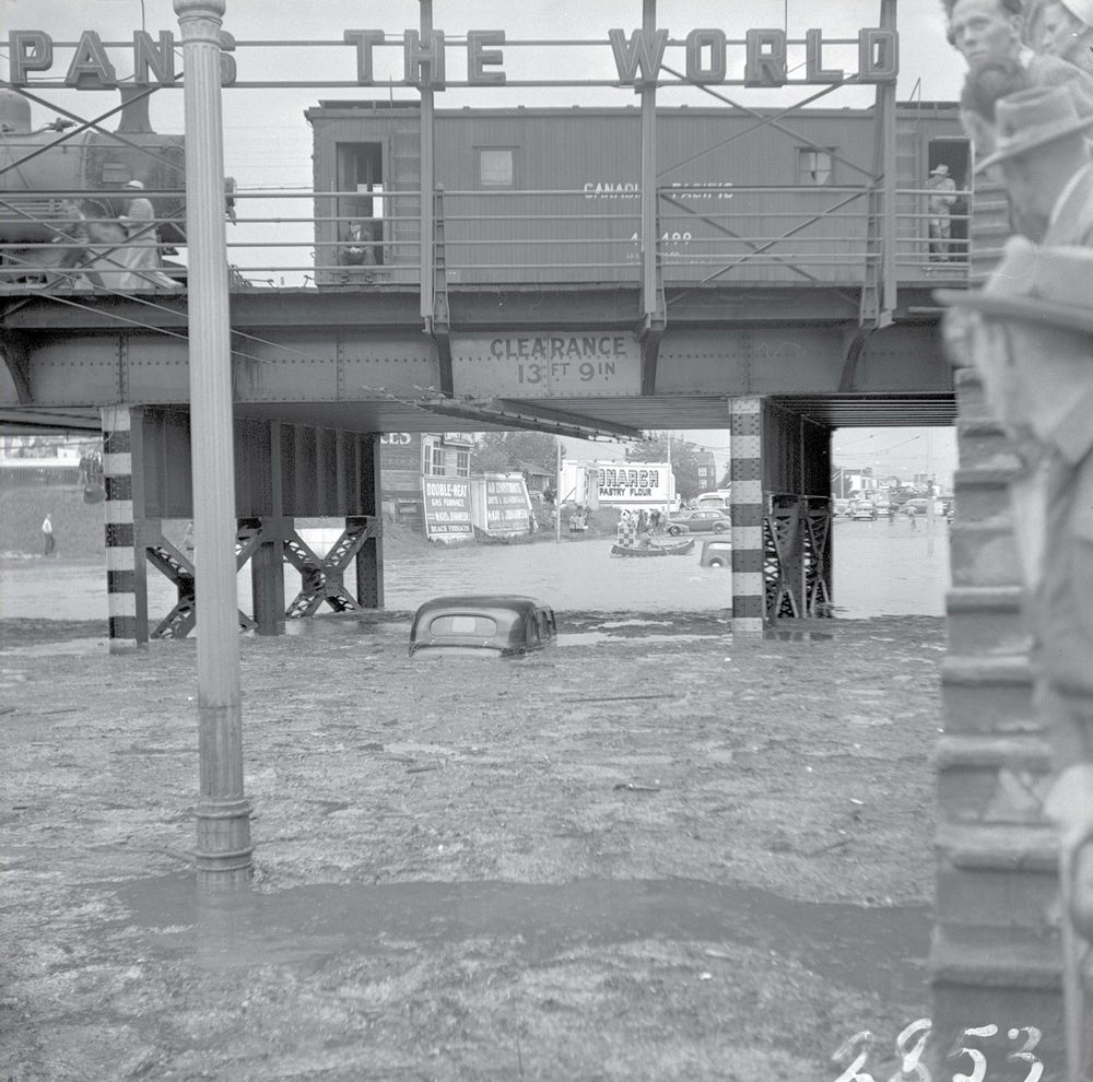 July 16, 1949 • Severe Thunder Storm

This was the scene along Jasper Ave. near 109 St. on this day over three-quarters of a century ago. The deluge was the city's heaviest short-period rainfall in its history. Cars were left trapped under the CPR underpass, while canoeists paddled their way down Jasper Avenue.

This view looking west to the flooded underpass on Jasper Avenue between 109th & 110th Street (CPR Subway)

📷 • Provincial Archives - Nick Ochotta (och1209)