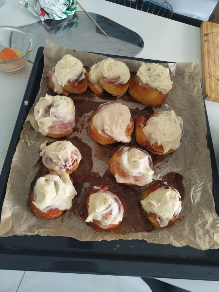 The same cinnamon rolls, now with sloppily applied white cream cheese frosting