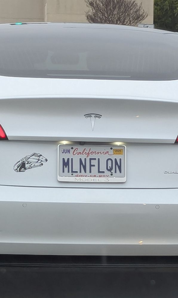 License plate number is MLNFLQN with a Millennium Falcon sticker next to it on the bumper. 