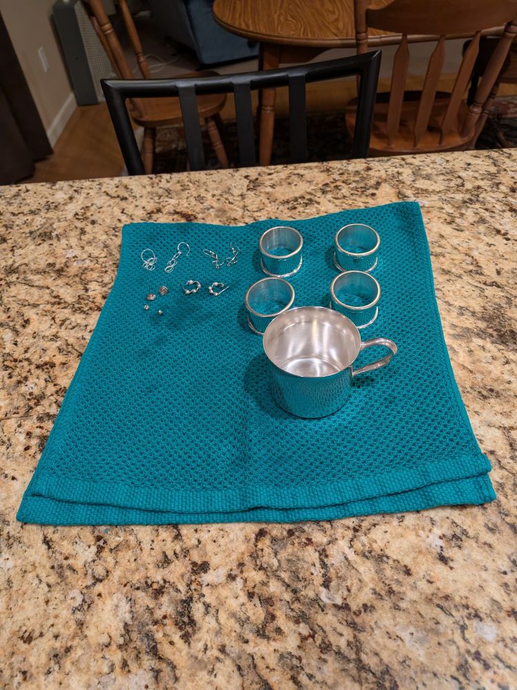 A silver cup, 4 napkin rings and some earrings.