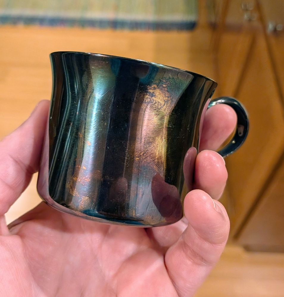 A extremely tarnished silver cup.