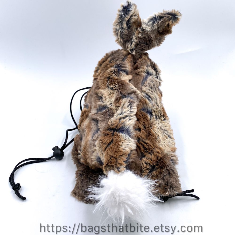 The back view of bunny tail on brown medium drawstring bag of devouring 