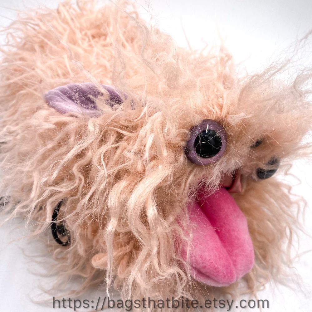 Crimped pale pink faux fur round mouth drawstring bag with a brighter pink tongue. Rose flop bunny ears are laid back along the bag. Big hand painted eyes are adorable and there is a tiny soft nose. 