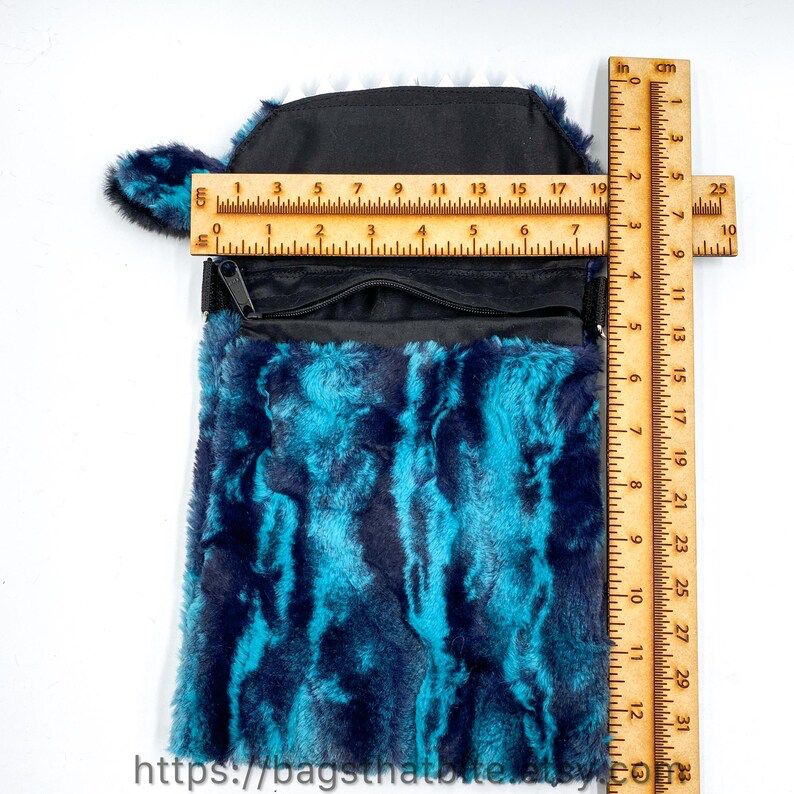 Ruler showing the zipper compartment of the bag is 7” across and about 9” deep. 