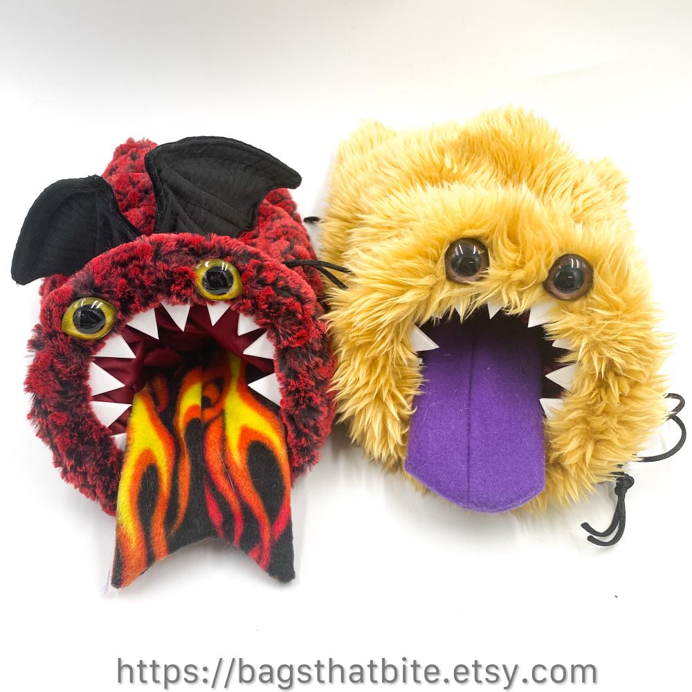 2 dice bags of devouring (if you feed them dice!) which are round mouth drawstring bags. The inner mouth is the one that closes, leaving the ring of foam teeth around the mouth to stay fierce. One bag is pretending to be a dragon, with red scaled faux fur and black boned wings and a fiery forked tongue and the other bag is wild tan fauxfurbags with purple tongue. 