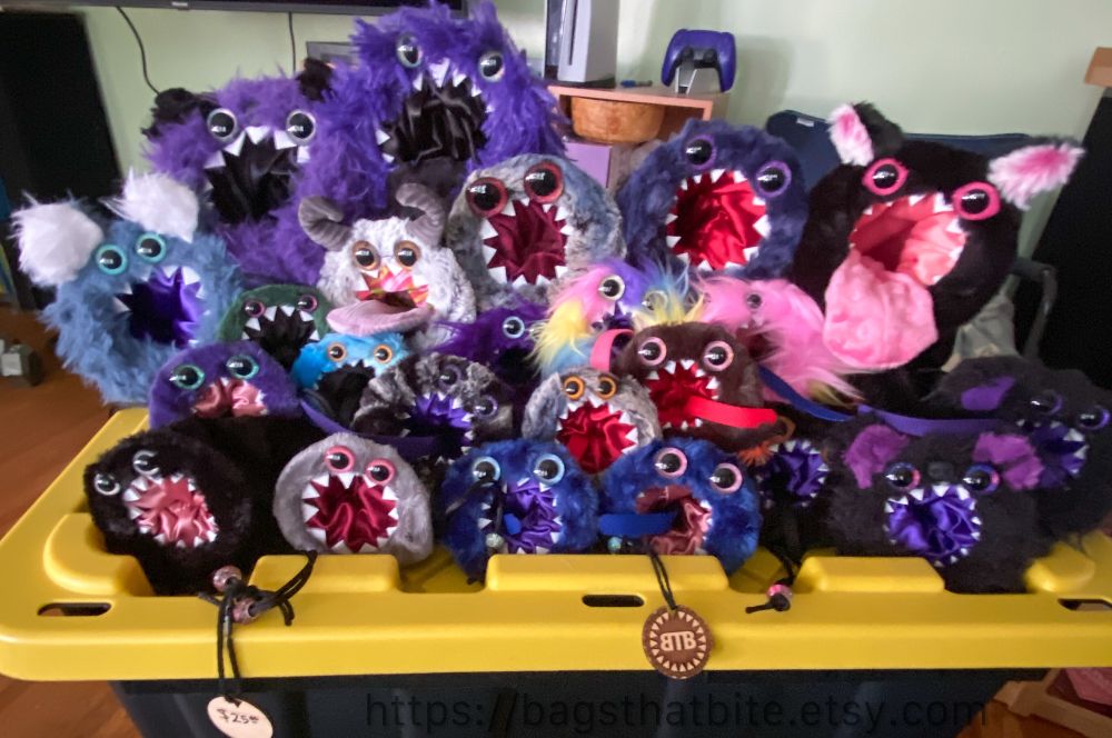 Many round mouth (dice) bags of devouring in many different colors and styles of faux fur. Each drawstring monster Bag has hand painted eyes and pointed foam teeth. 