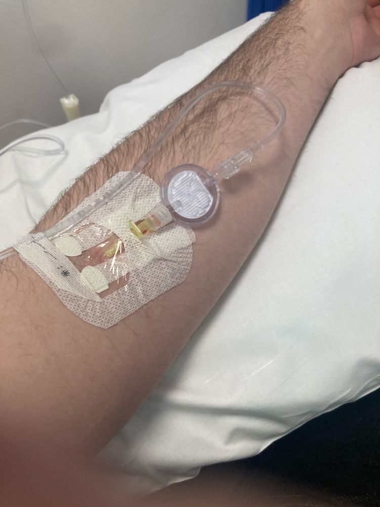 My left arm hooked up to an IV drip, receiving treatment. 