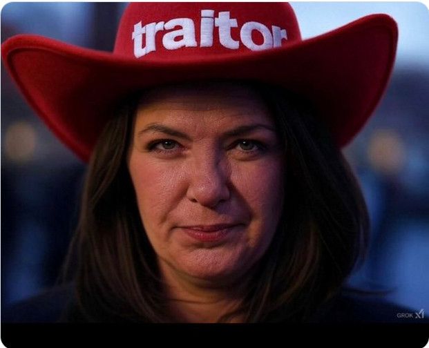 Danielle Smith wearing a red cowboy hat that reads Traitor.