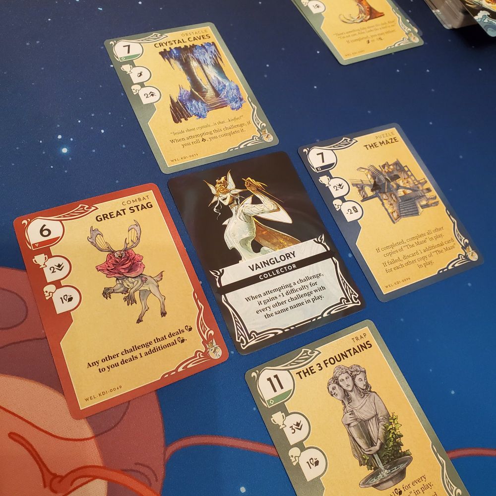 Five cards in a "plus" pattern on top of a blue and red playmat.