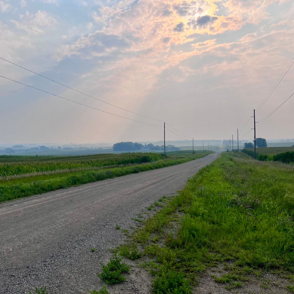 A gravel road, with rolling hills in the distance. 