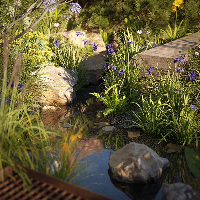 Small pool of water with boulders and plants. A path leads to it and there is a metal grid over part of the water.