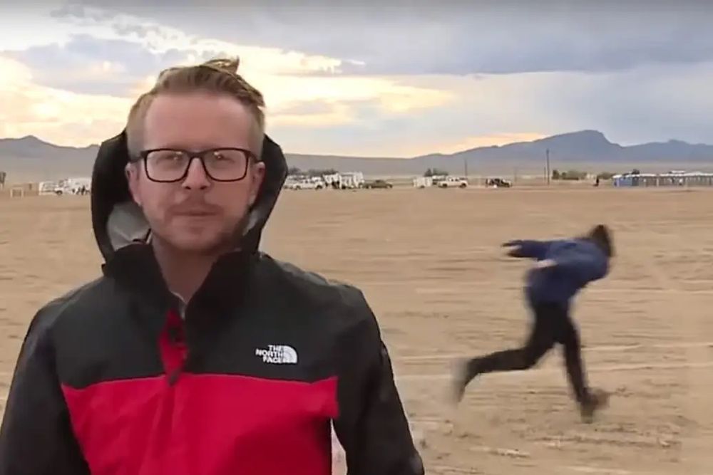 A young person Naruto runs past a news broadcaster during a “raid” on “Area 51”