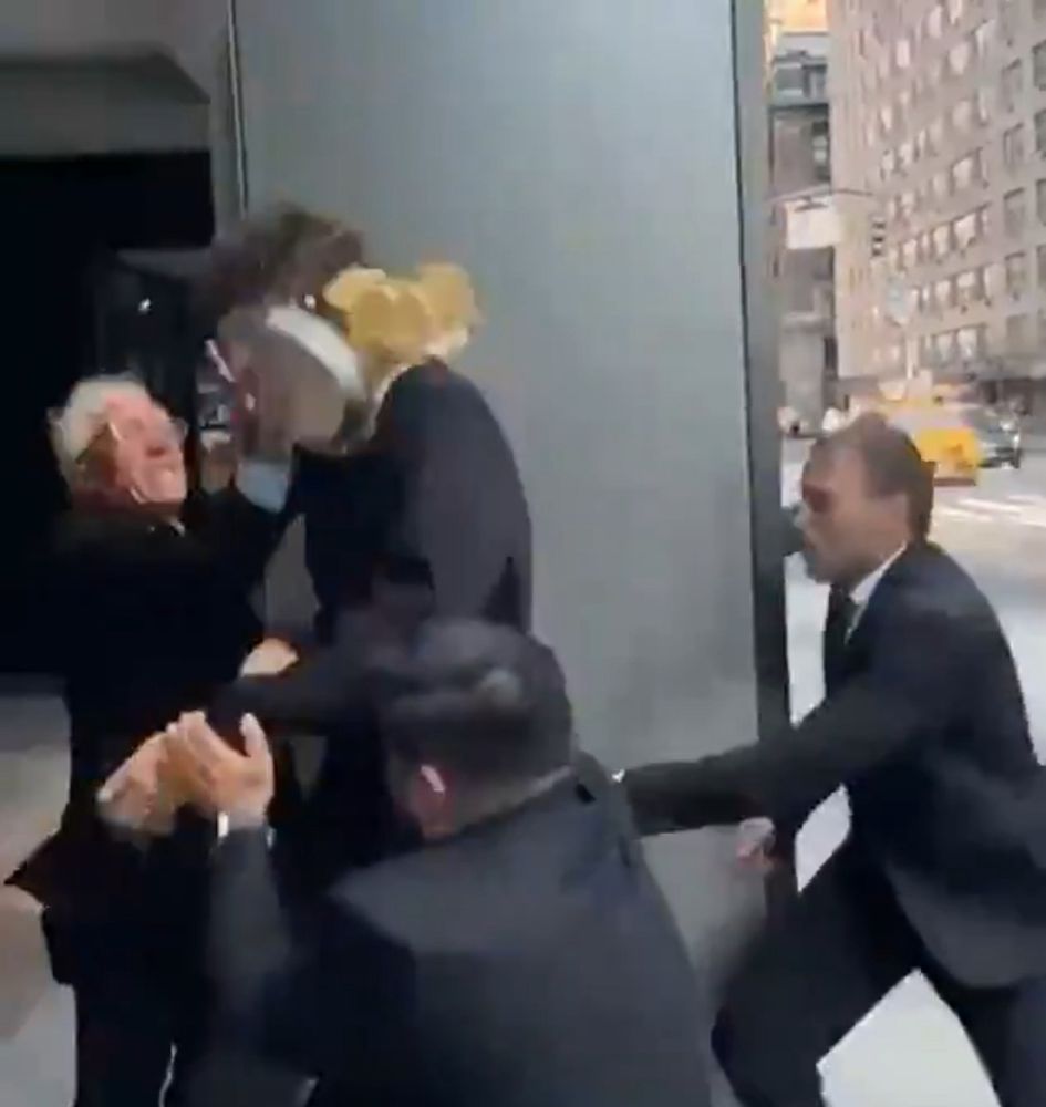 A screenshot from the video I quoted where an old man pies a ceo in the face while their security detail is lacking. Looks like Bernie sanders from the quality of the video 