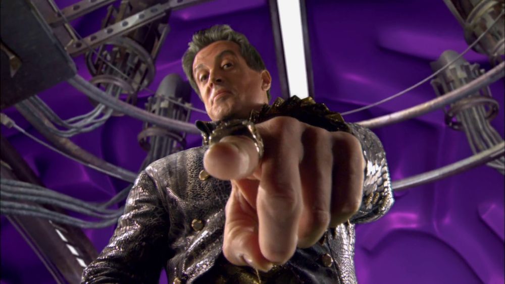 screencap from Spy Kids 3 - you're looking up at Sylvester Stallone who's extending a finger towards you, as though he's about to poke you in the face