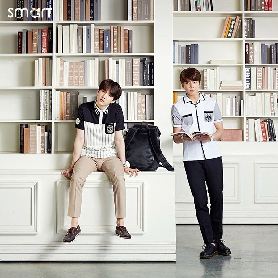 Yoongi and Jungkook for Smart. Yoongi is sitting on the edge of a bookshelf and JK is leaning against it.