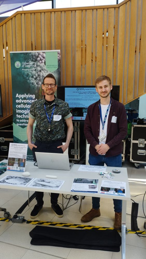 Bioimaging team members standing in front of a showcasing stall, representing the diverse research facilities of Exeter University.
