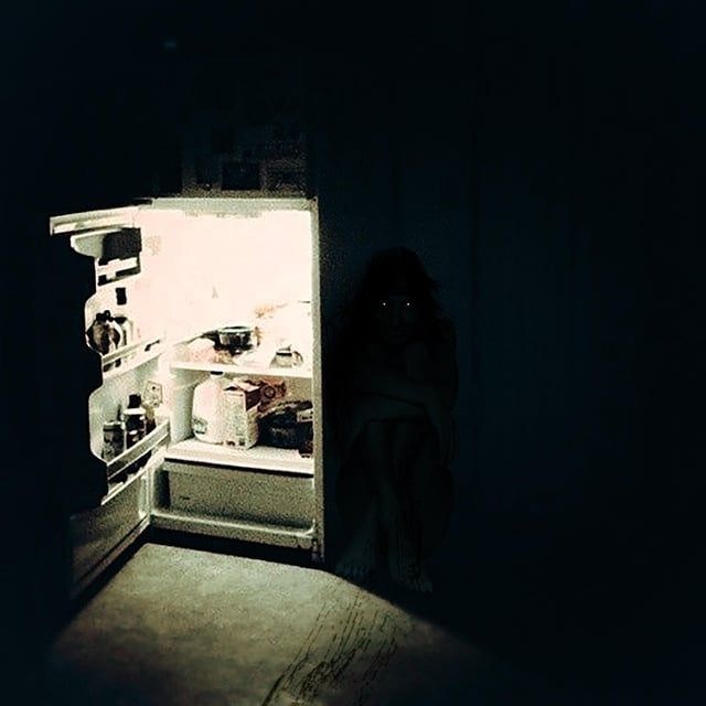 A monster hides behind an open fridge.