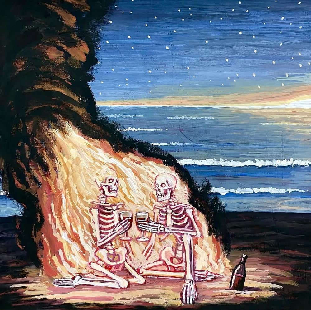 Two skullies toast red wine at the beach while engulfed in flames