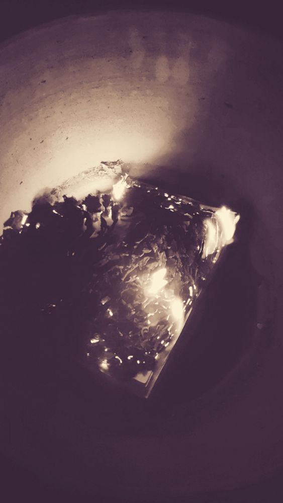 Smouldering book ashes inside a container