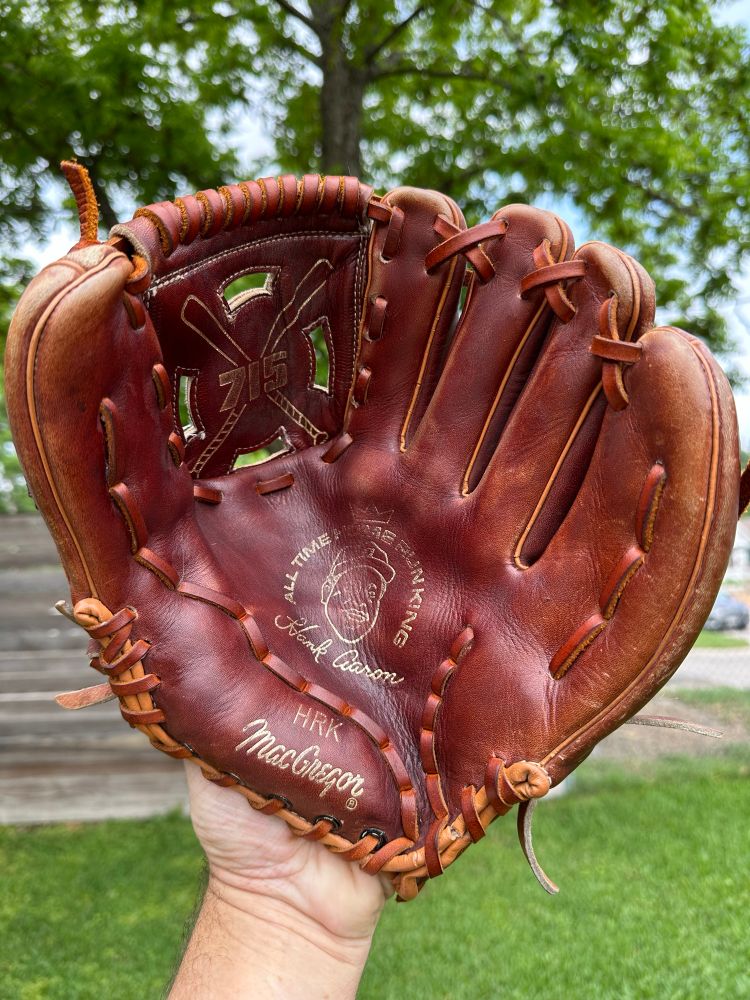 A special issue MacGregor HRK glove celebrating Hank Aaron’s 715th home run in 1974. The palm features a portrait of Hank in gold ink, encircled by the words “ALL TIME HOME RUN KING” and his signature underneath. The pocket features crossed bats and the number 715.