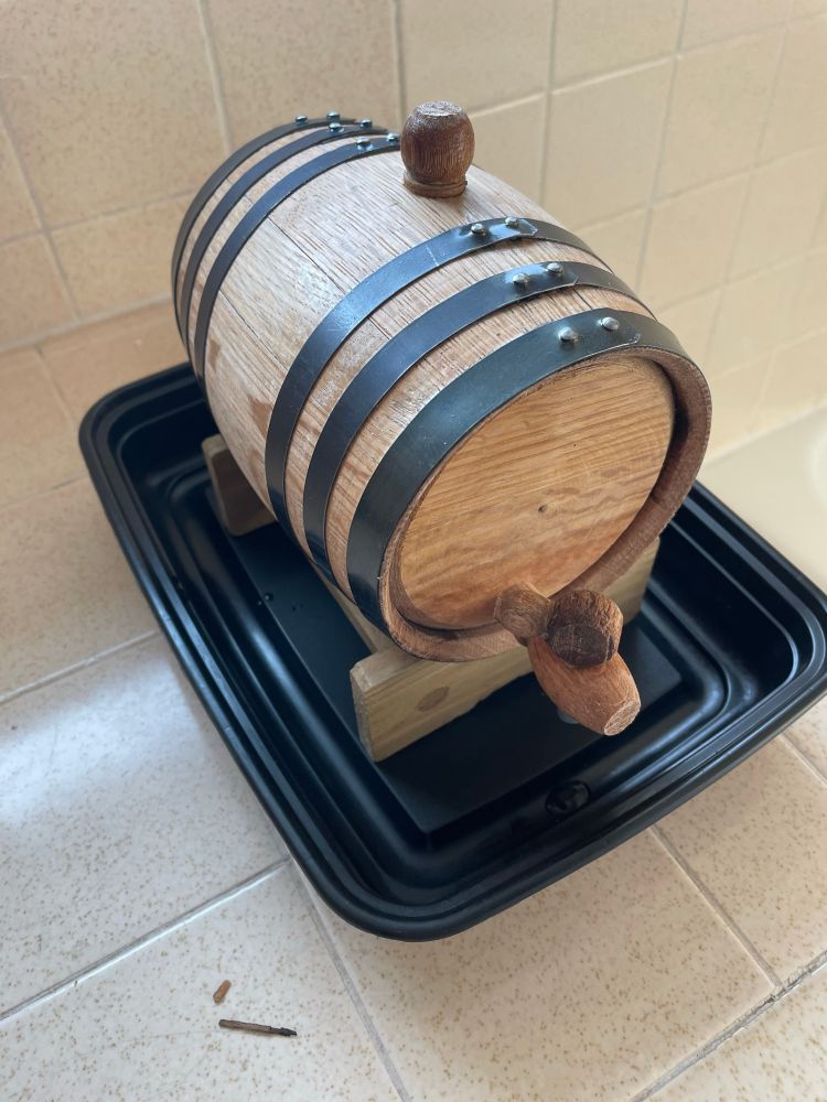 Photos of oak barrel plugged full of water to make it swell and seal up.