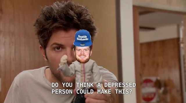 Adam Scott from Parks and Rec holds up a doll with the head of Sam Darnold, the Seahawks' new QB, wearing a Seahawks hat. The caption reads "Do you think a depressed person could make this?" 