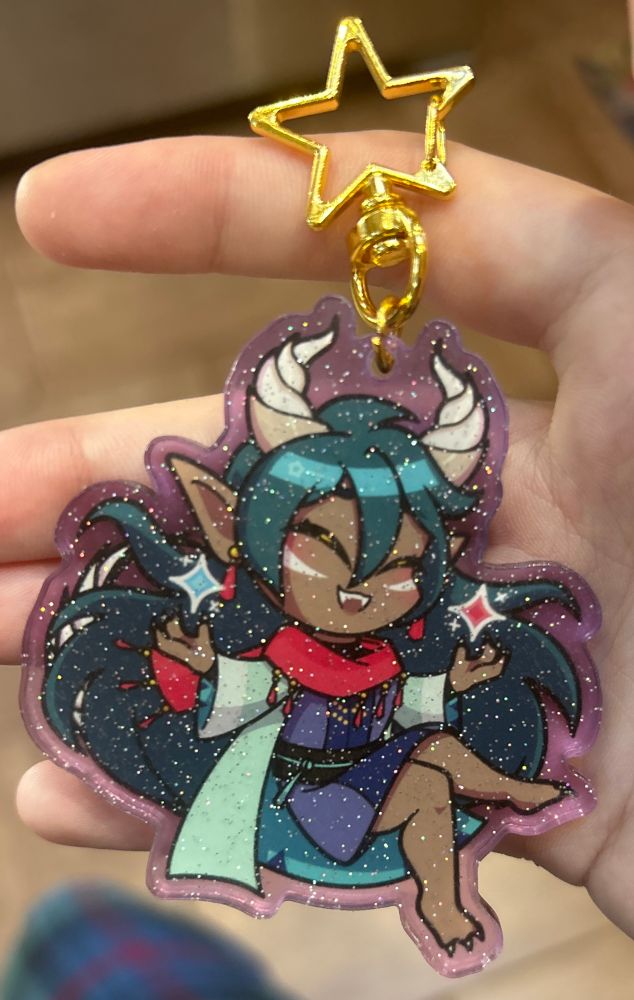 acrylic glitter keychain of a chibi Caldarus from fields of mistria 