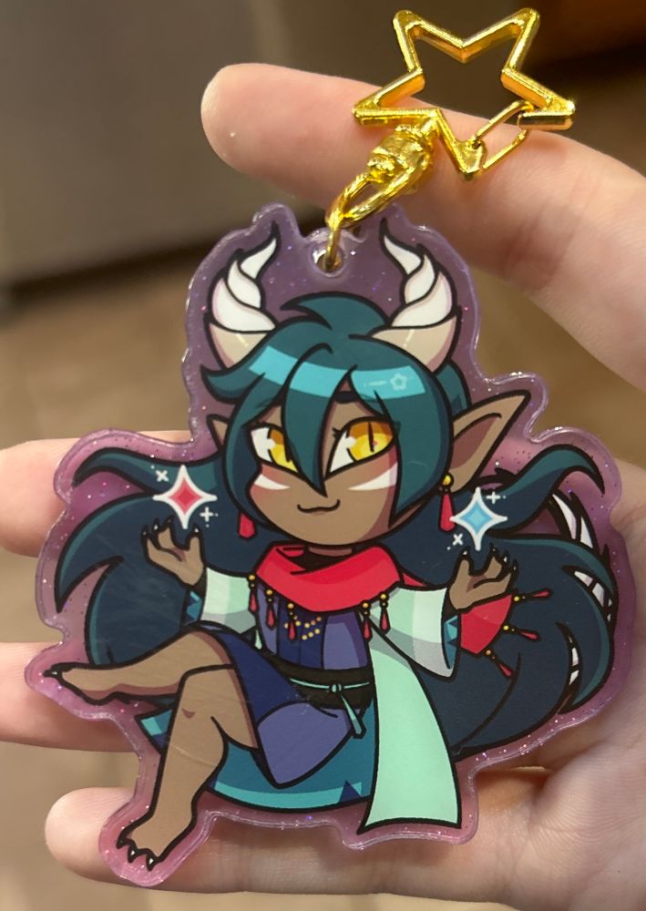 acrylic glitter keychain of a chibi Caldarus from fields of mistria 