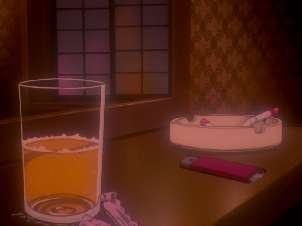 A glass of orange liquid, a condom wrapper, a lighter, and two cigarette butts in an ashtray