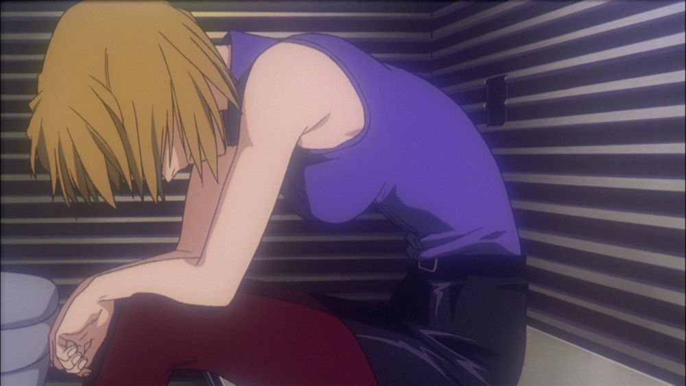 Ritsuko hunched over in a jail cell