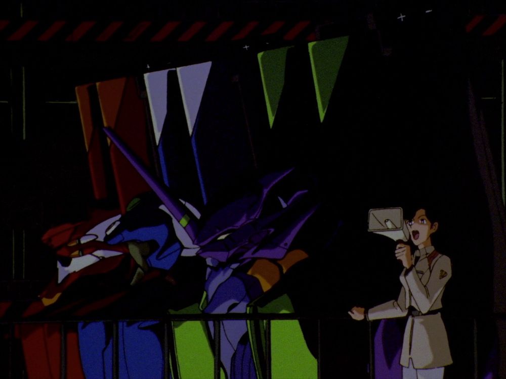 Maya speaking into a megaphone in front of Units 02, 00, and 01.