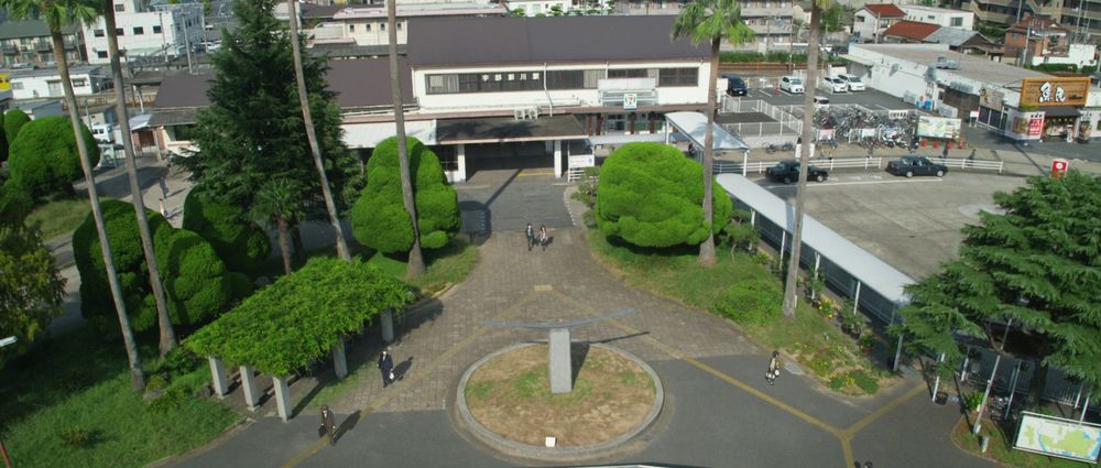 Mari and Shinji running from the train station into the real world