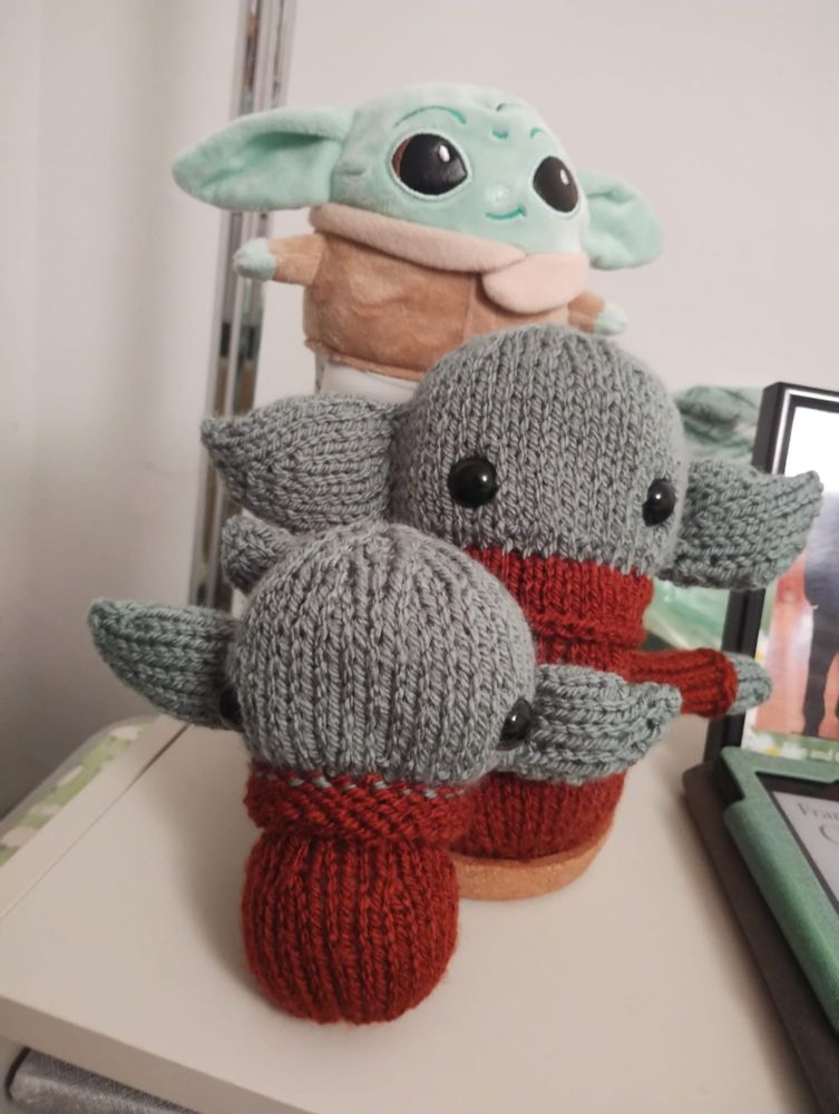 Three baby Yoda/Grogu plushies posing ominously for the camera 