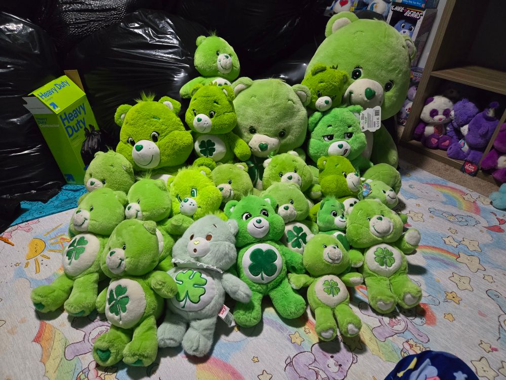 A collection of about 30ish Green Good luck bear care bear stuffed animals of varying sizes