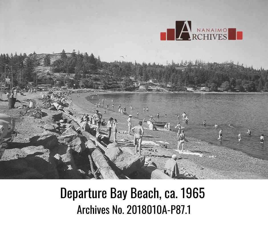 Photograph of the Departure Bay Beach with swimmers in Nanaimo, around 1965