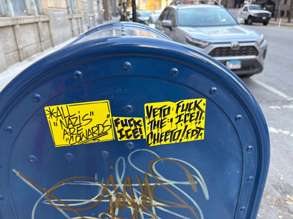 Blue U.S. mailbox with three yellow stickers with black lettering. 
1. *All “Nazis” are cowards* 
2. Fuck ICE 
3. Veto the Cheeto/FDT  FUCK ICE!!