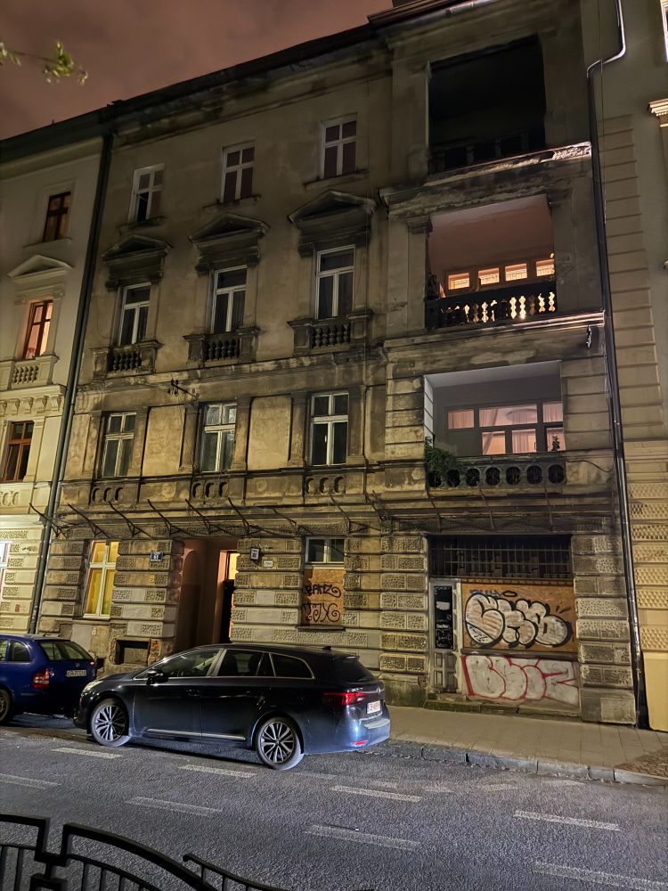 photo of old four story apartment building with graffiti on the bottom floors.