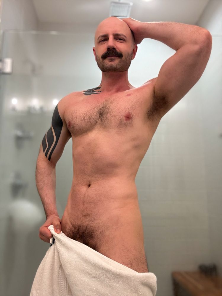 Me posing nude in my bathroom with a white towel around my no-no spot, showing my hairy pit and bush. 