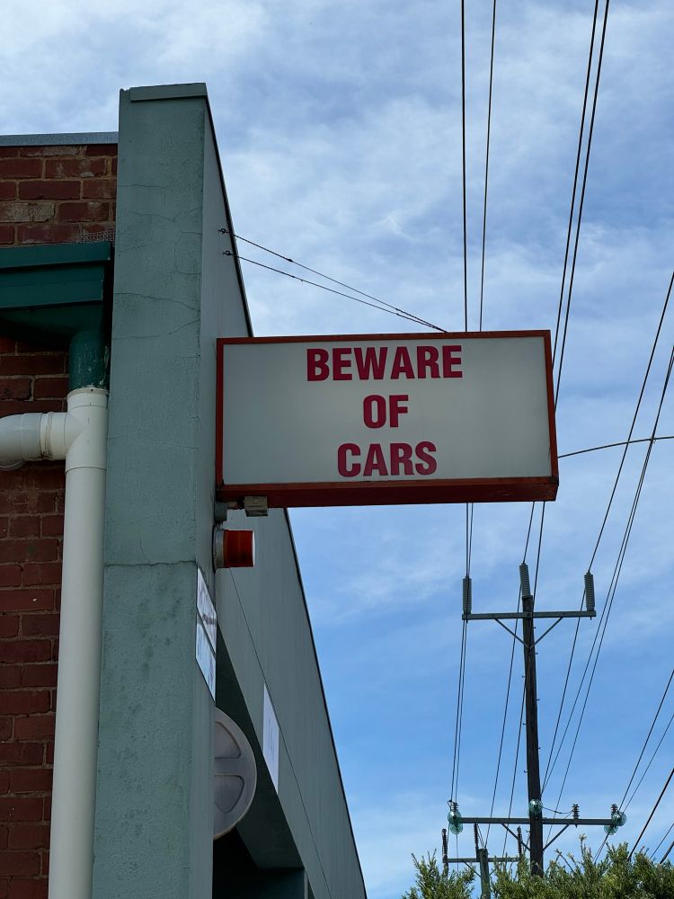 A sign that says “beware of cars”