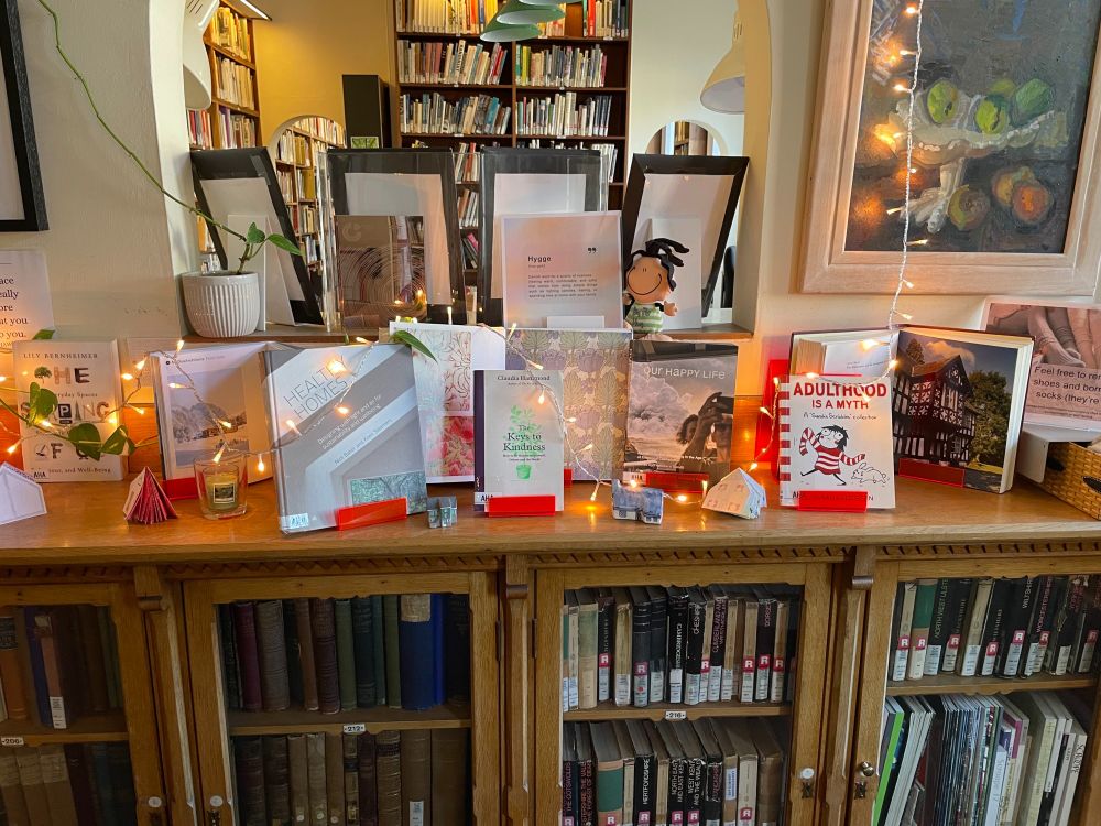 A photo of the library Hugge display, with the selection of books, warm socks to borrow, and fairy lights by the books.