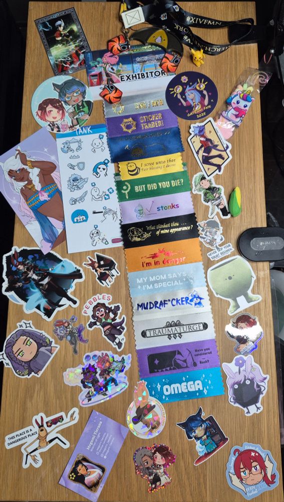 Gateway FATE exibitor badge surrounded by Warrior of Light Stickers and fan merch from FFXIV 