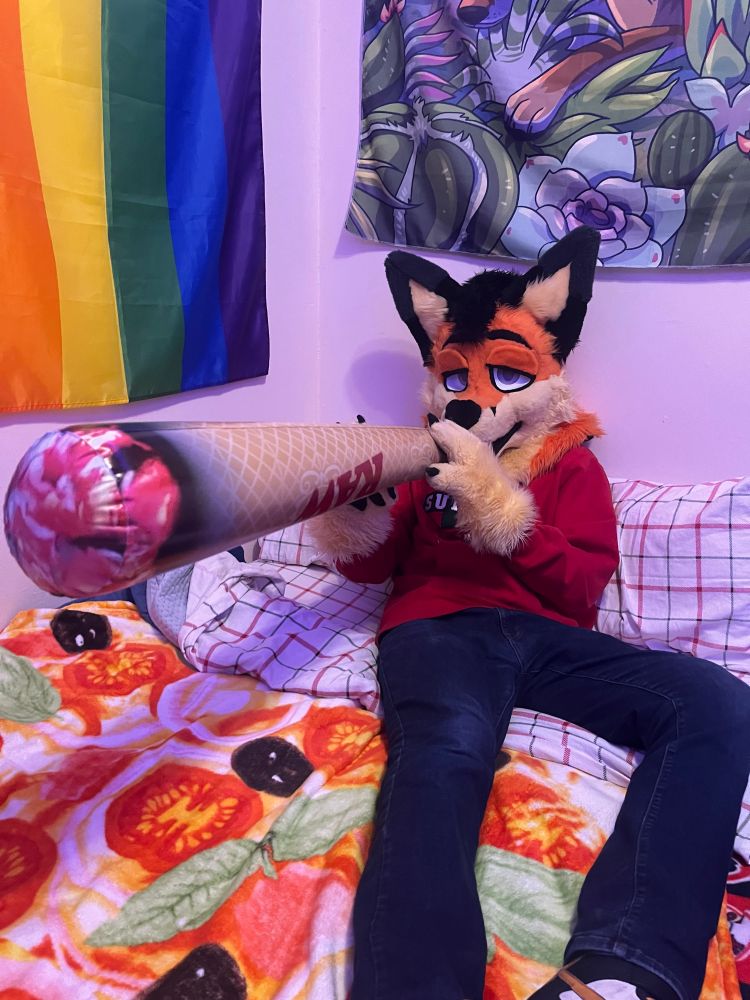 Ray in fursuit pretending to smoke a large inflatable joint