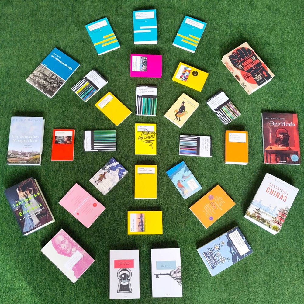 Auf grünem Hintergrund sind etwa 30 Bücher kreisförmig arrangiert.