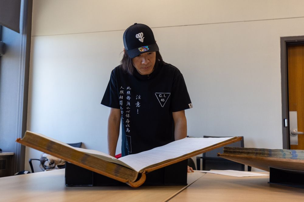 Eric looking at a large book of records.