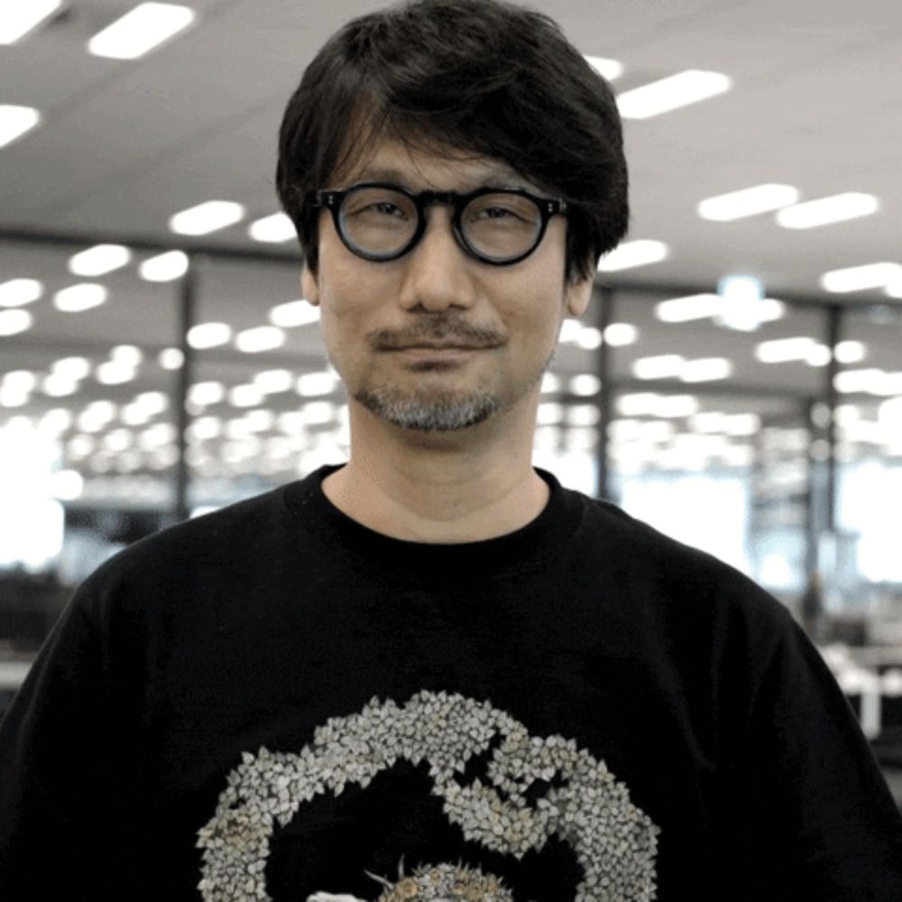 a man with glasses and a beard wears a black shirt with a star wars logo on it