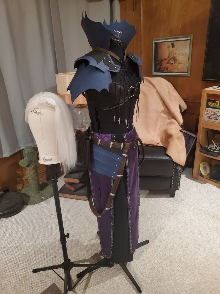 A photo of my Abdirak cosplay on a maniquin, as well as the wig on the eig stand next to it