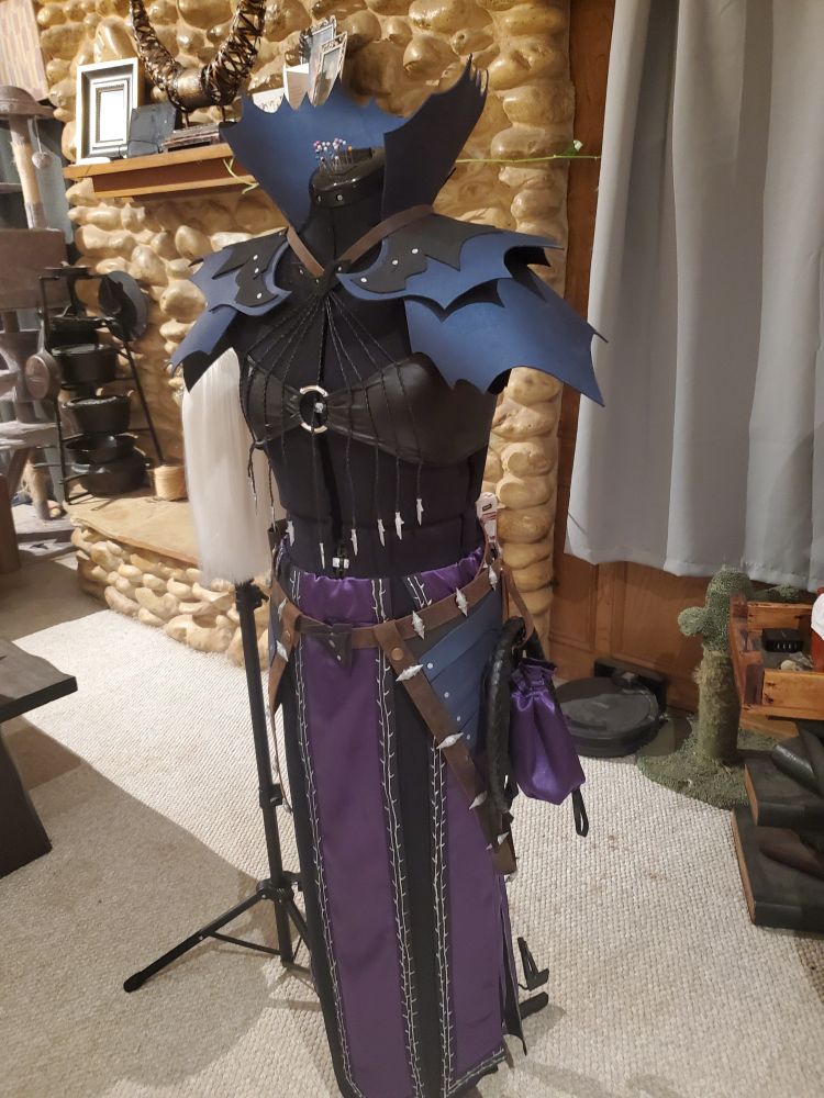 A photo of my Abdirak cosplay on a maniquin, as well as the wig on the eig stand next to it
